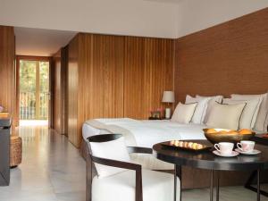 a hotel room with a large bed and a table at Victoria Golf Resort and Spa Managed by Accor in Vilamoura