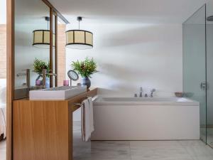a bathroom with a large white tub and a sink at Victoria Golf Resort and Spa Managed by Accor in Vilamoura