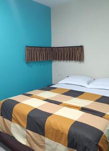 a blue bedroom with a bed with a striped blanket at Rumah Marianne in Sorong