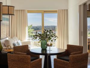 a living room with a vase of flowers on a table at Victoria Golf Resort and Spa Managed by Accor in Vilamoura