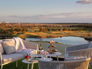 a patio with a couch and a table with a view at Victoria Golf Resort and Spa Managed by Accor in Vilamoura