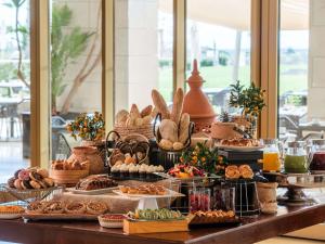a buffet of bread and pastries on a table at Victoria Golf Resort and Spa Managed by Accor in Vilamoura