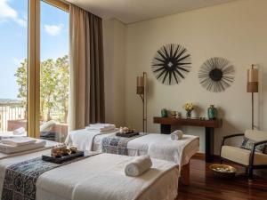 a hotel room with two beds and a window at Victoria Golf Resort and Spa Managed by Accor in Vilamoura