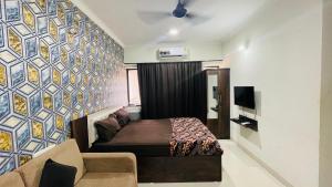 a bedroom with a bed and a couch and a wall at Studio flats in Candolim in Candolim