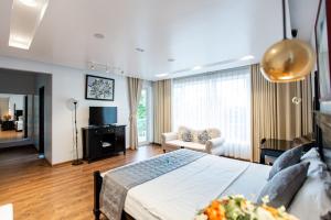 a bedroom with a bed and a living room at Villa Pearl FLCSầm Sơn in Sầm Sơn