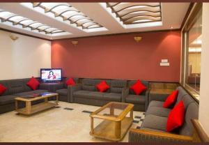 a living room with couches and red pillows at Hotel Sea Palace Ltd in Cox's Bazar