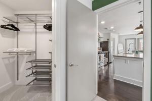a walk in closet with a glass door leading to a kitchen at Reynoldstown Lux 2BR, Rooftop Deck, Near Beltline & Downtown, Free Parking in Atlanta +33 photos
