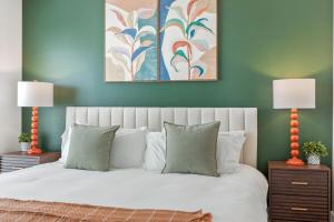 a bedroom with a white bed with two lamps at Reynoldstown Lux 2BR, Rooftop Deck, Near Beltline & Downtown, Free Parking in Atlanta
