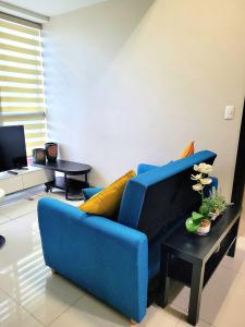 a blue couch sitting in a living room at BGC Uptown Park Suites Tower 1 - 2 Bedroom and 2 Bath Condo in Manila