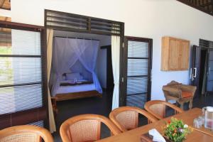 comedor con cama, mesa y sillas en Villa Bayu, en Temukus