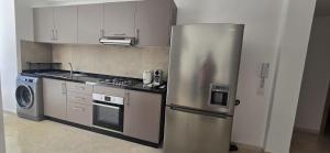 a kitchen with a stainless steel refrigerator and a stove at Dar Sofia Noria in Marrakech