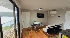 a living room with a table and a balcony at Alta Vista Pino Huacho in Valdivia