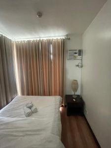 a bedroom with a bed with two towels on it at A venue Residences 1801 in Manila