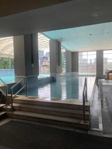 a large indoor swimming pool with water in a building at A venue Residences 1801 in Manila