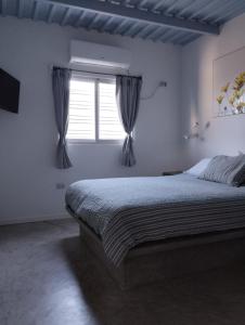 a white bedroom with a bed and a window at Altos de Guarame in Flandes