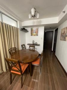 a dining room with a wooden table and chairs at A venue Residences 1801 in Manila