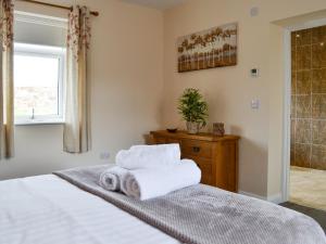ein Schlafzimmer mit einem Bett mit Handtüchern darauf in der Unterkunft Liftingstane Cottage in Closeburn
