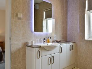 ein Badezimmer mit einem weißen Waschbecken und einem Spiegel in der Unterkunft Liftingstane Cottage in Closeburn + 10 Fotos