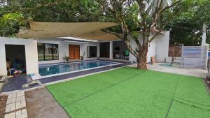a house with a swimming pool and a tree at Casa Zavia in Sampong