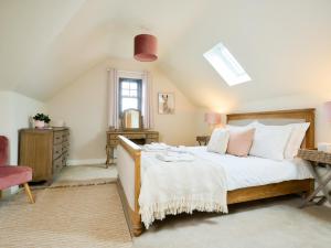 a bedroom with a bed with white sheets and pink pillows at Seasalt in Mundesley +10 photos