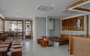 a restaurant with wooden tables and benches and a bar at Hommory Residence - East Chalong in Phuket