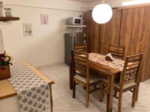 a kitchen and dining room with a table and chairs at Studio apartment in split level bungalow with pool access in Cochin