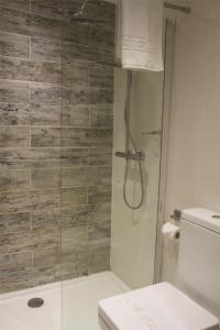 a bathroom with a toilet and a shower stall at The Oak House Hotel in Axbridge