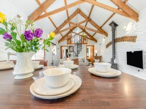 a wooden table with cups and flowers on it at Hunters Lodge - Uk41503 in Saint Twynnells