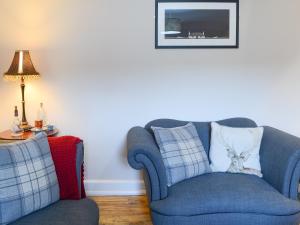 a living room with a blue chair and a lamp at Wallace House in Dornoch