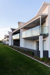 Reflections By Rockingham Apartments في روكينجهام: صف من مباني الشقق مع حديقة خضراء
