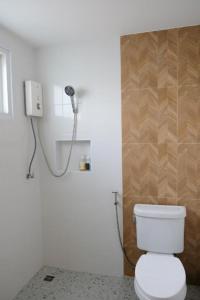 a bathroom with a white toilet and a shower at The Loom Rangsit in Ban Lam Phak Kut