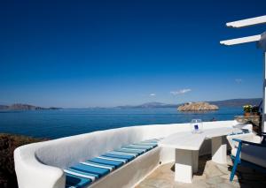 d'une terrasse blanche avec une table et une vue sur l'océan. dans l'établissement Villa Ostria, à Vlikhós