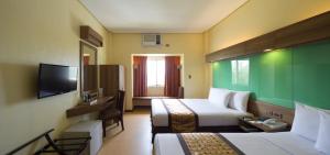 ein Hotelzimmer mit 2 Betten und einem TV in der Unterkunft Microtel by Wyndham General Santos in General Santos