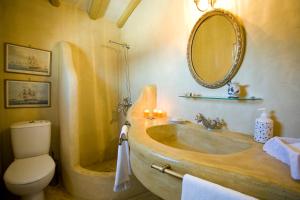 a bathroom with a sink and a toilet and a mirror at Villa Ostria in Vlikhós