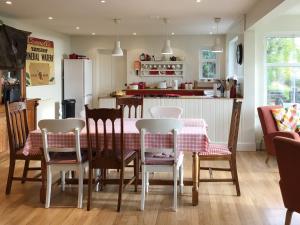Una cocina y un comedor con mesa y sillas. en Owl Cottage, en Kilmote