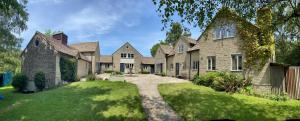 ein großes Backsteinhaus mit Auffahrt in der Unterkunft Derrybrook Cottage, Twin or Superking, Seven Springs Cottages in Cheltenham