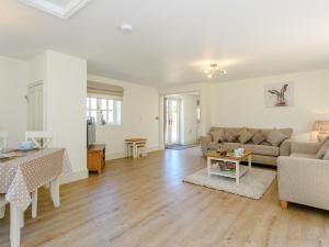 un salon avec un canapé et une table dans l'établissement Woodcutters Cottage, à Fulletby