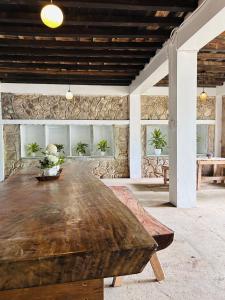 a large wooden table in a room with a stone wall at Mountain River Lodge Room in Daraitan Tanay Rizal Philippines in Laiban