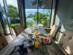 a wooden table with food and drinks on top of it at Blue Wave Hotel Hua Hin in Hua Hin