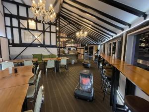 Un restaurante con mesas y sillas y una estufa en el medio. en Hakuba Sun Valley Hotel Annex - Vacation STAY 90316v, en Iida
