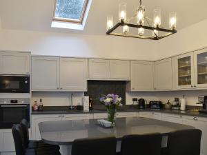 eine Küche mit einem Tisch mit einer Vase mit Blumen darauf in der Unterkunft The Cottage in Bewdley
