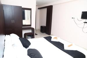 a person sitting on a bed in a bedroom at Erica Hotel International in Perintalmanna