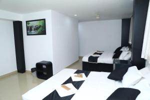 a hotel room with two beds and a television at Erica Hotel International in Perintalmanna