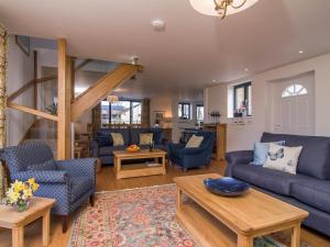 a living room with blue couches and a table at The Coach House - Ukc2772 in Sandwich