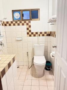 a bathroom with a white toilet in a room at Buakao Inn in Thongsala