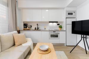 a living room with a couch and a table and a kitchen at Arena One Studio in Fuengirola