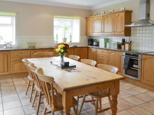 a kitchen with a wooden table and chairs at The Mill House in Warenford