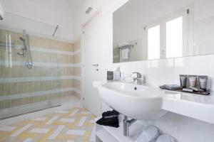 een witte badkamer met een wastafel en een spiegel bij Firriato Hospitality - Calamoni di Favignana Apartments in Favignana