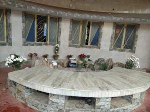 a circular stone table in front of a building with windows at Bichitrita Homestay in Shānti Niketan