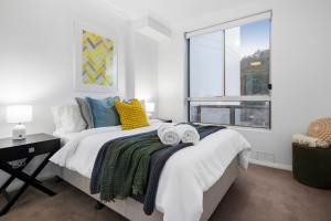 a bedroom with a bed with towels on it at Two-Story Penthouse Apartment in Gosford